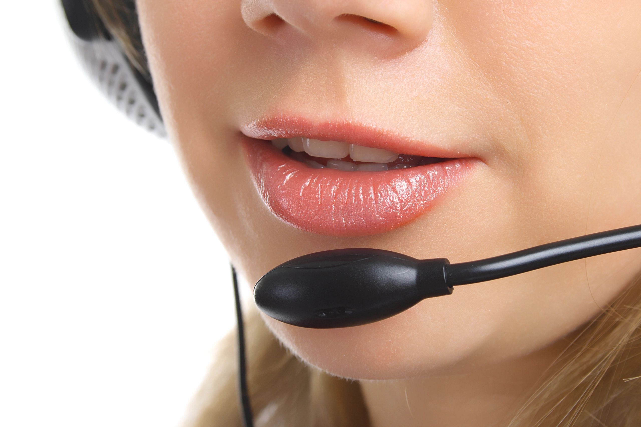 Close-up of a woman's mouth and headset, indicating a communication or call center setting.